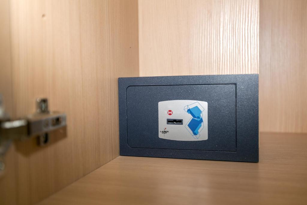 Elle comprend une petite télévision avec une boîte bleue et blanche sur une table. dans l'établissement Hotel Colonna, à Lido di Jesolo