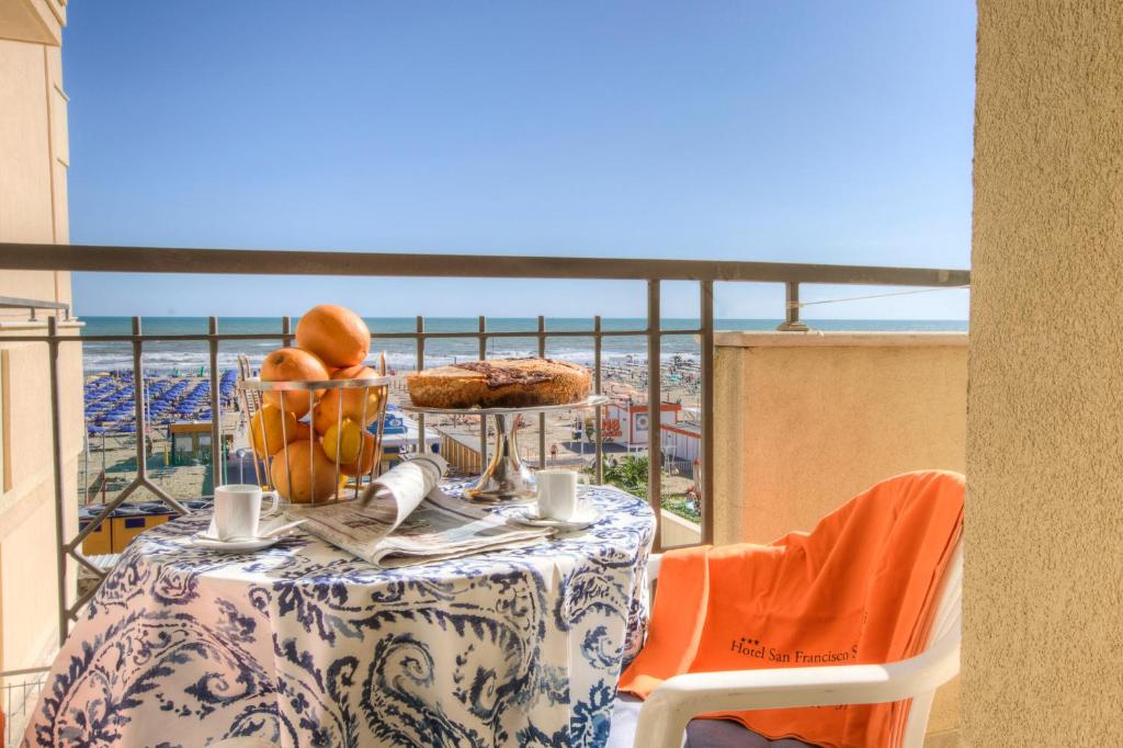 une table avec une assiette de nourriture sur un balcon dans l'établissement Hotel San Francisco Spiaggia, à Rimini