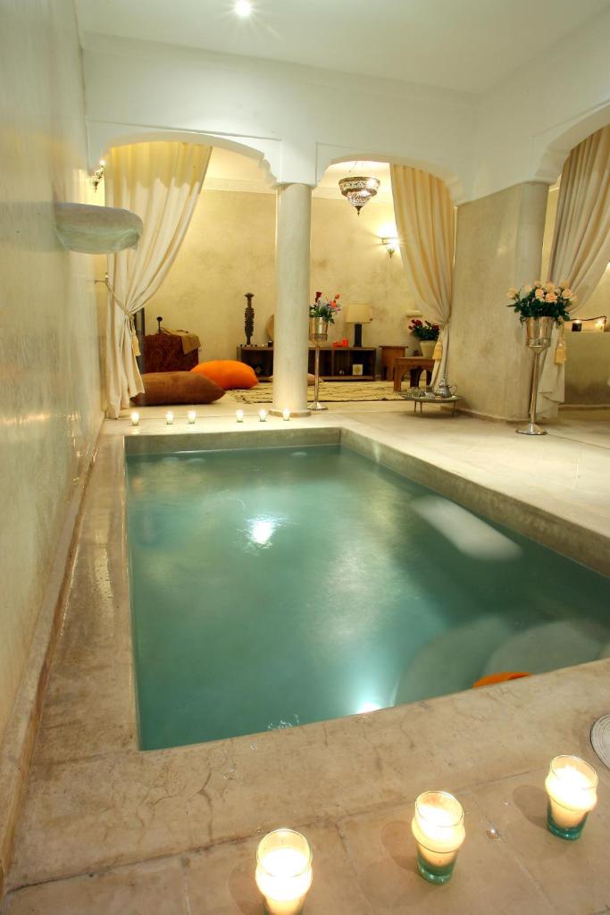 - une piscine dans une chambre avec bougies et lumières dans l'établissement Riad CHERRATA, à Marrakech