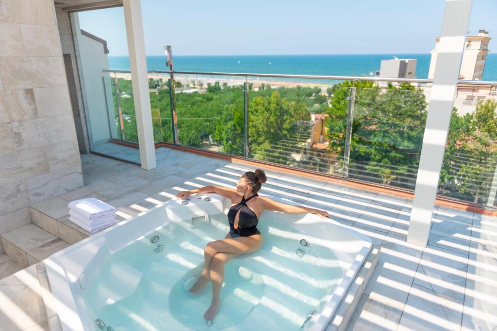une femme assise dans un jacuzzi dans une maison dans l'établissement Hotel Atlantic Riviera Mare, à Misano Adriatico
