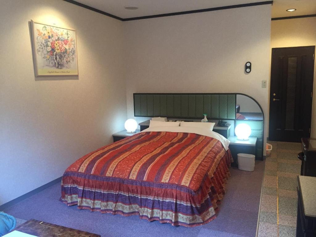 - une chambre avec un grand lit et deux lumières sur dans l'établissement Hotel Sango (Adult only), à Muroran