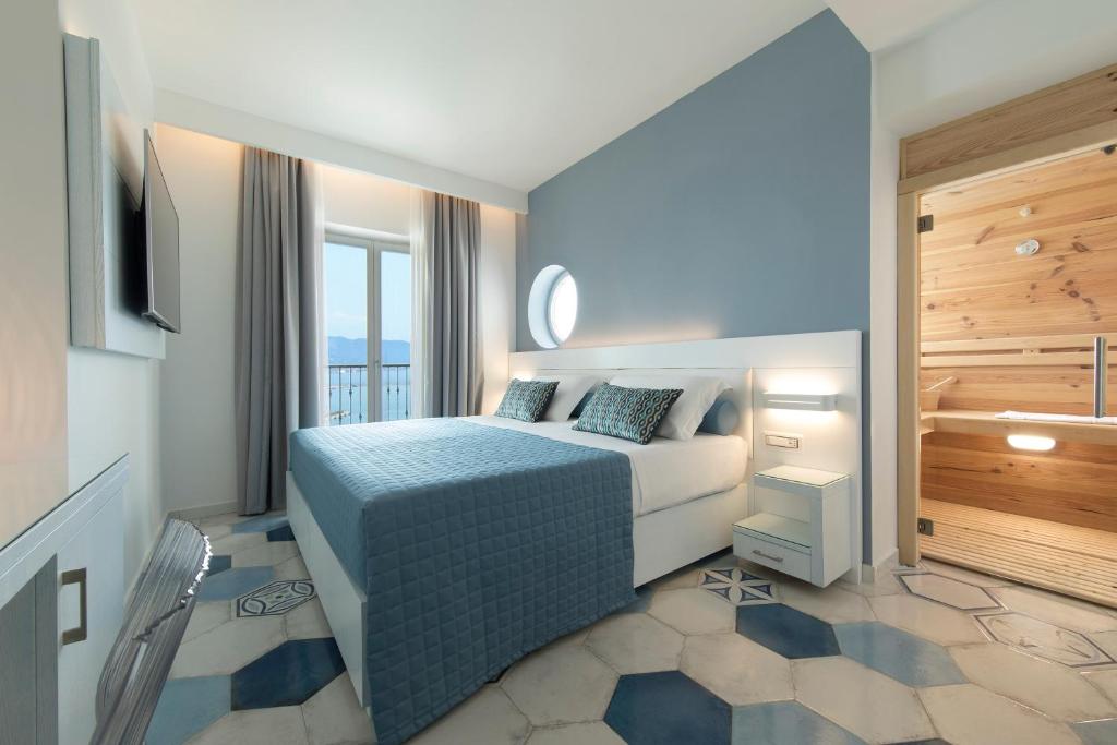 une chambre d'hôtel avec un lit et un balcon dans l'établissement Lloyd's Baia Hotel, à Vietri