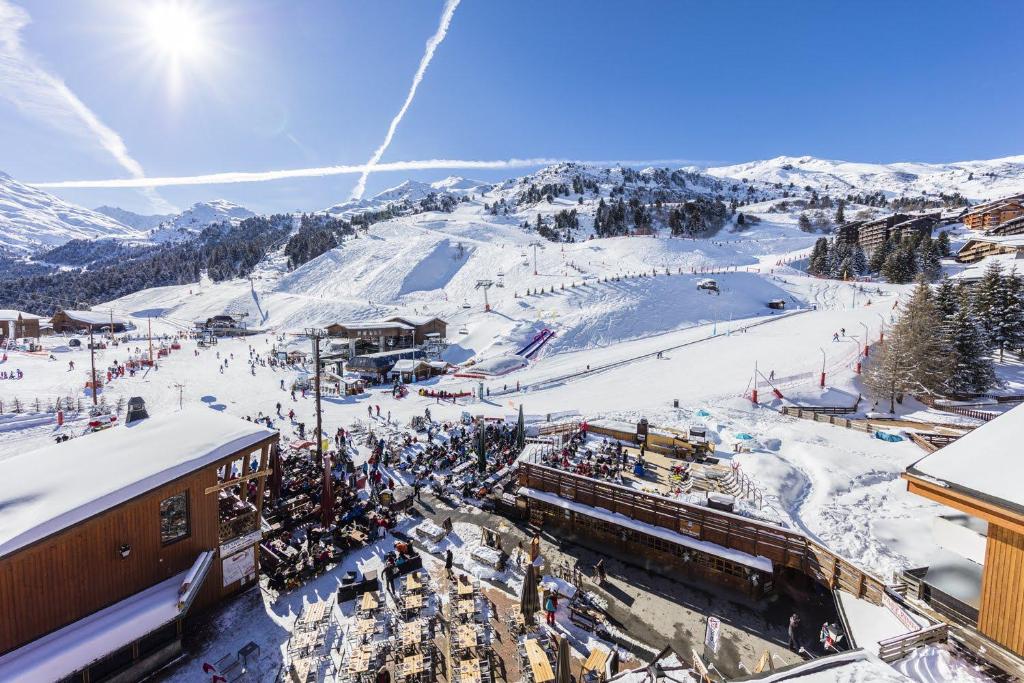 une station de ski avec une foule de personnes sur une piste de ski dans l'établissement Hôtel Alpen Ruitor, à Méribel 37 autres photos
