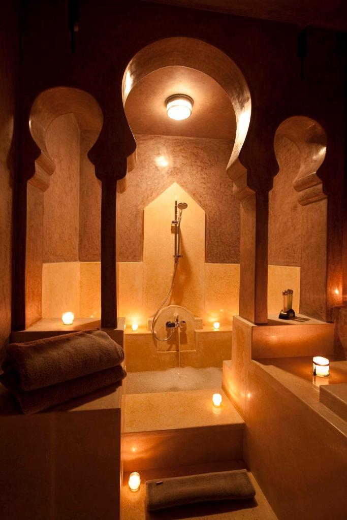 La salle de bains est pourvue d'une baignoire et d'un lavabo éclairé. dans l'établissement Riad Dar Maya, à Essaouira