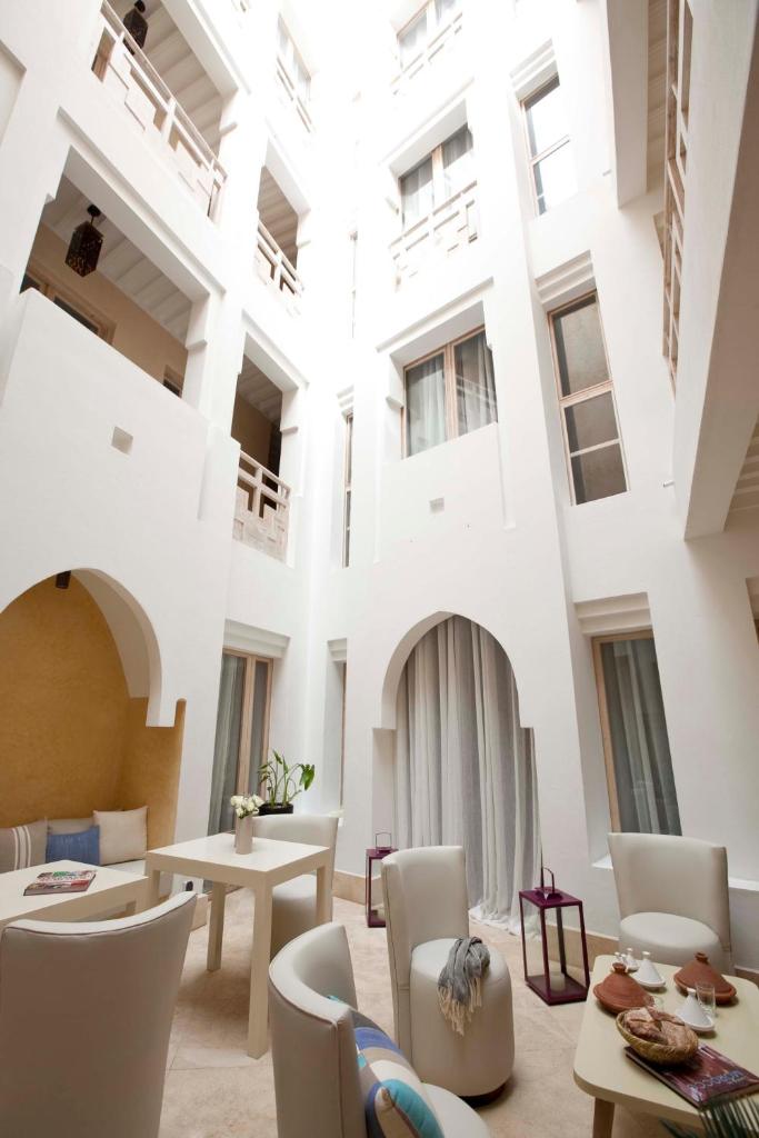 un grand bâtiment blanc avec des tables et des chaises dans l'établissement Riad Dar Maya, à Essaouira