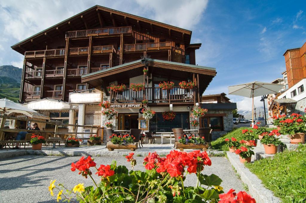 un bâtiment avec des fleurs devant lui dans l'établissement Hôtel Le Refuge, à Tignes