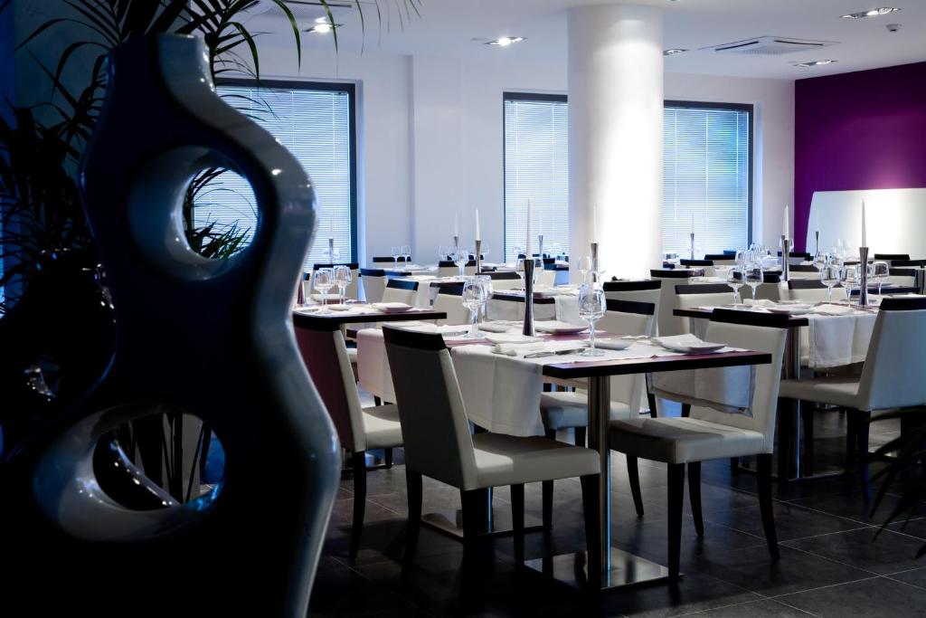 une salle à manger avec des tables et des chaises blanches dans l'établissement Hotel Napoleon, à Torre Melissa