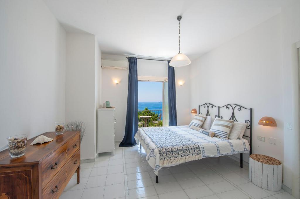 une chambre avec un lit et une fenêtre avec l'océan dans l'établissement Villa Giulia, à Praiano