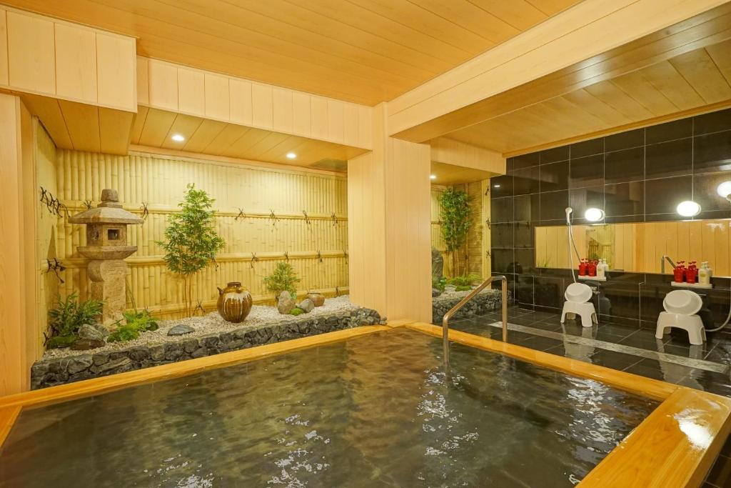 une piscine dans une maison avec un étang dans l'établissement SEVEN SEAS HOTEL ITO (セブンシーズホテル）, à Itō
