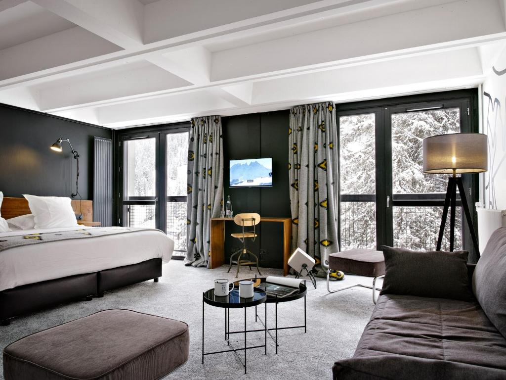 une chambre d'hôtel avec un lit et un canapé dans l'établissement Totem, Friendly Hotel & Spa, à Flaine