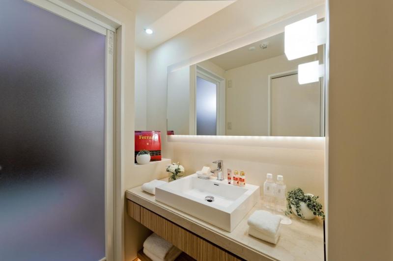 une salle de bain avec un lavabo et un grand miroir dans l'établissement Hotel ROY YOKOHAMA, à Yokohama 12 autres photos