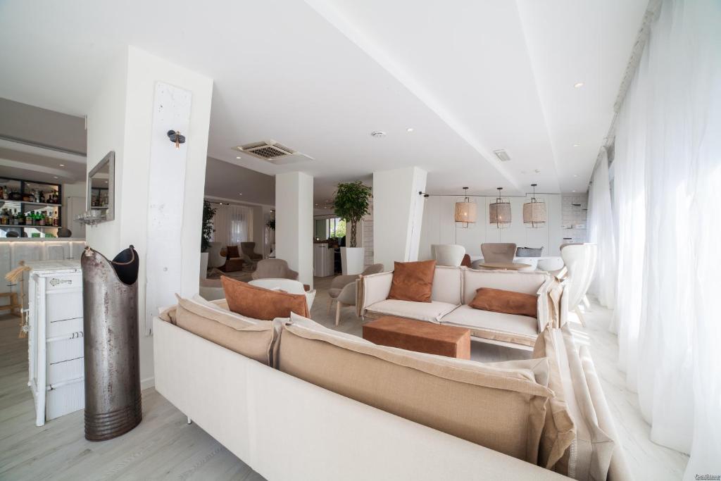 Elle comprend un salon doté d'un mobilier blanc et d'un mur blanc. dans l'établissement Hotel Solemare, à Milano Marittima