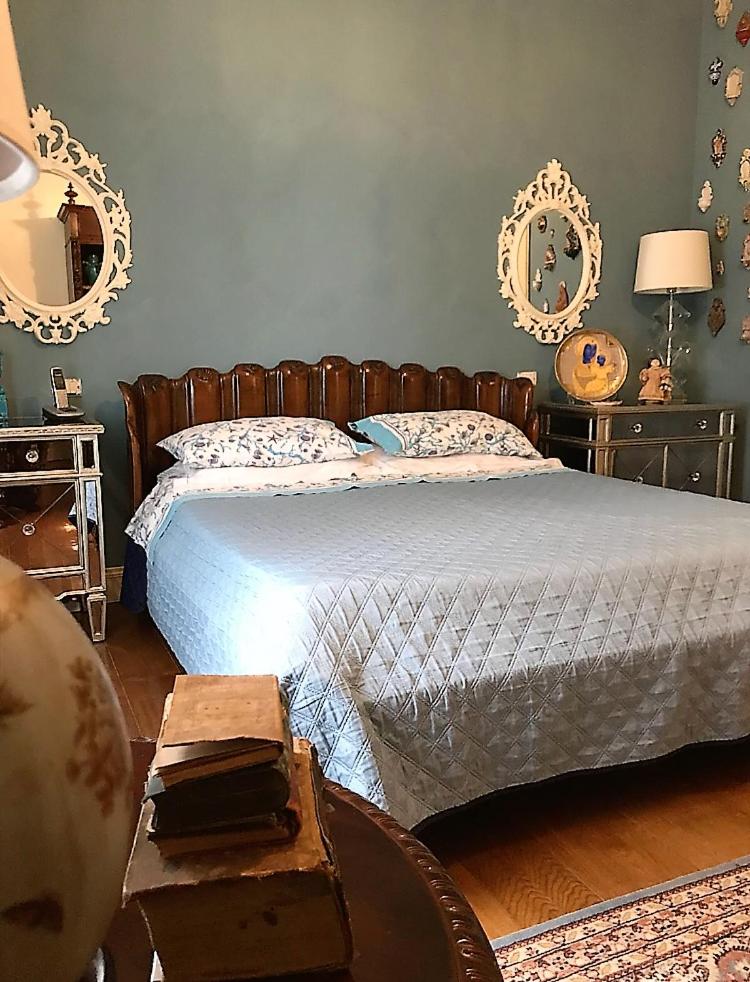 - une chambre avec un lit, une table et des miroirs dans l'établissement The queen's house, à Agrigente