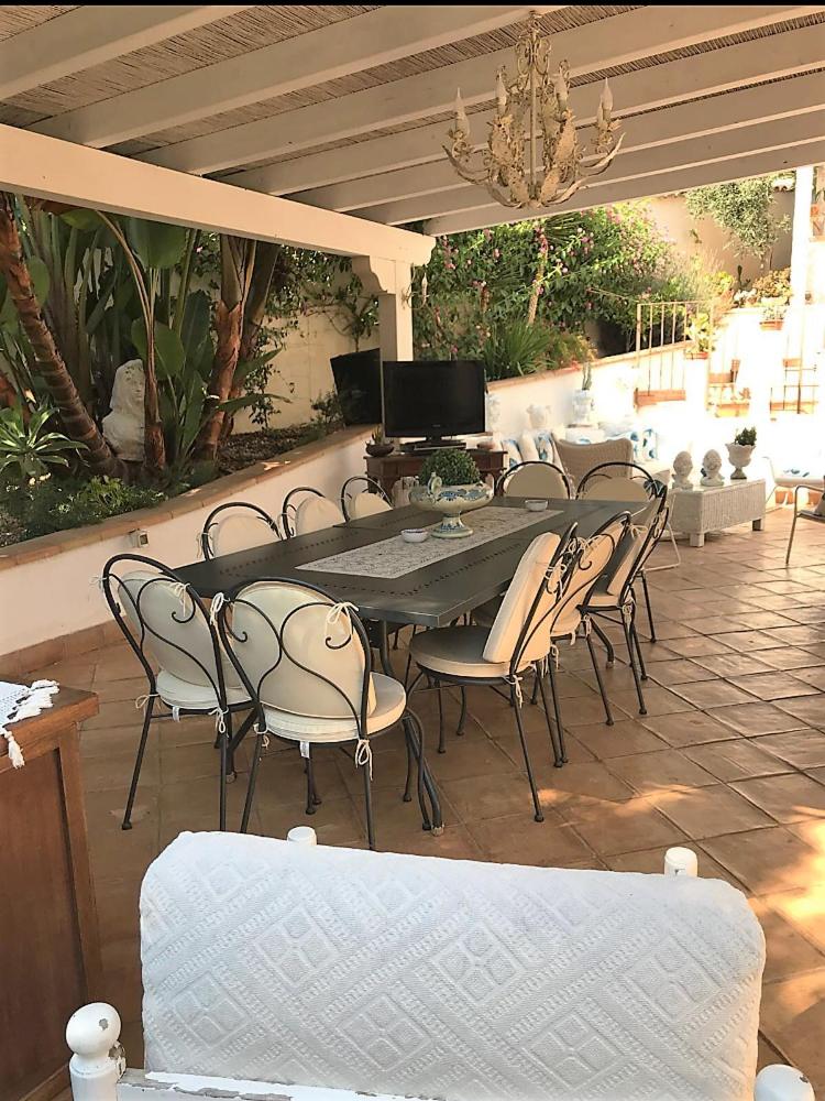 une grande table et des chaises sur la terrasse dans l'établissement The queen's house, à Agrigente
