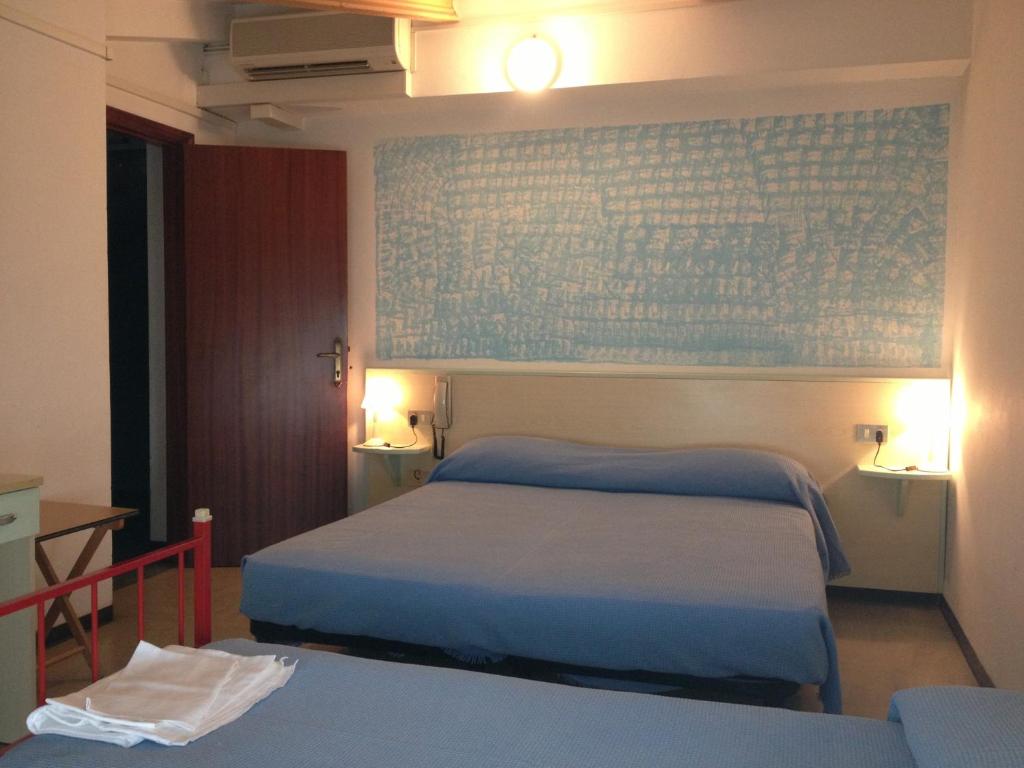 une chambre avec deux lits et un mur bleu dans l'établissement Hotel Rivamare, à Massignano