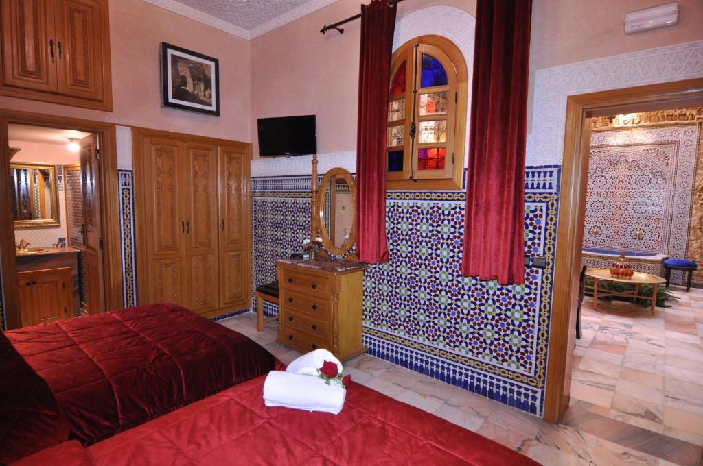 une chambre avec un lit, une commode et un miroir dans l'établissement Dar Al Madina Al Kadima, à Fès