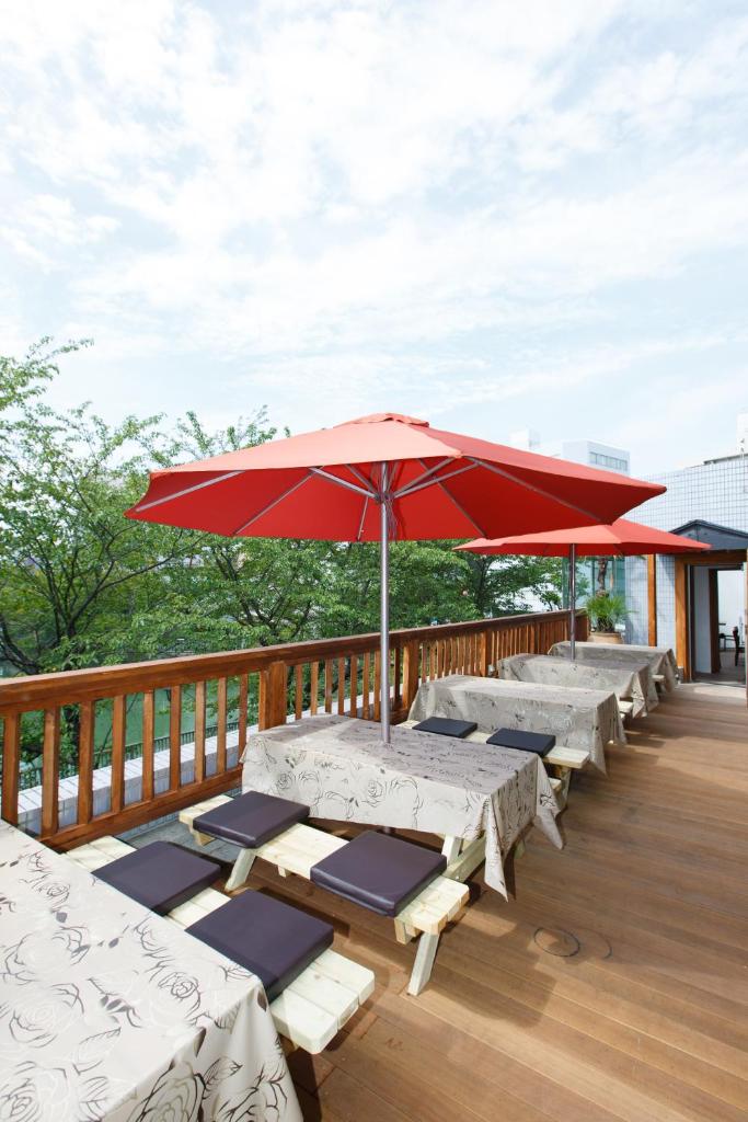 une rangée de tables et un parasol sur une terrasse dans l'établissement Day Nice Hotel Tokyo, à Tokyo