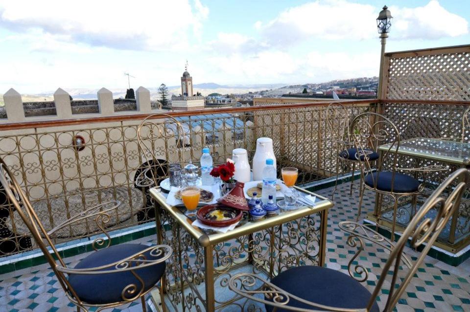 une table avec de la nourriture et des boissons sur un balcon dans l'établissement Dar Al Madina Al Kadima, à Fès