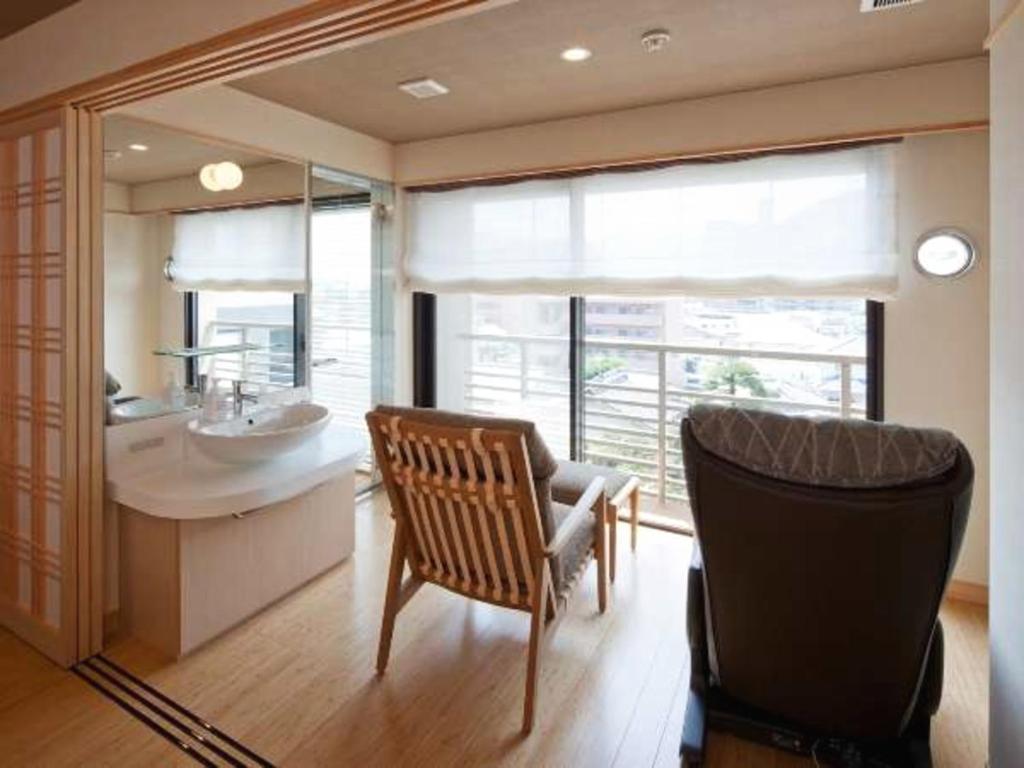 La salle de bains est pourvue d'une chaise, d'un lavabo et d'un miroir. dans l'établissement Hana Beppu, à Beppu