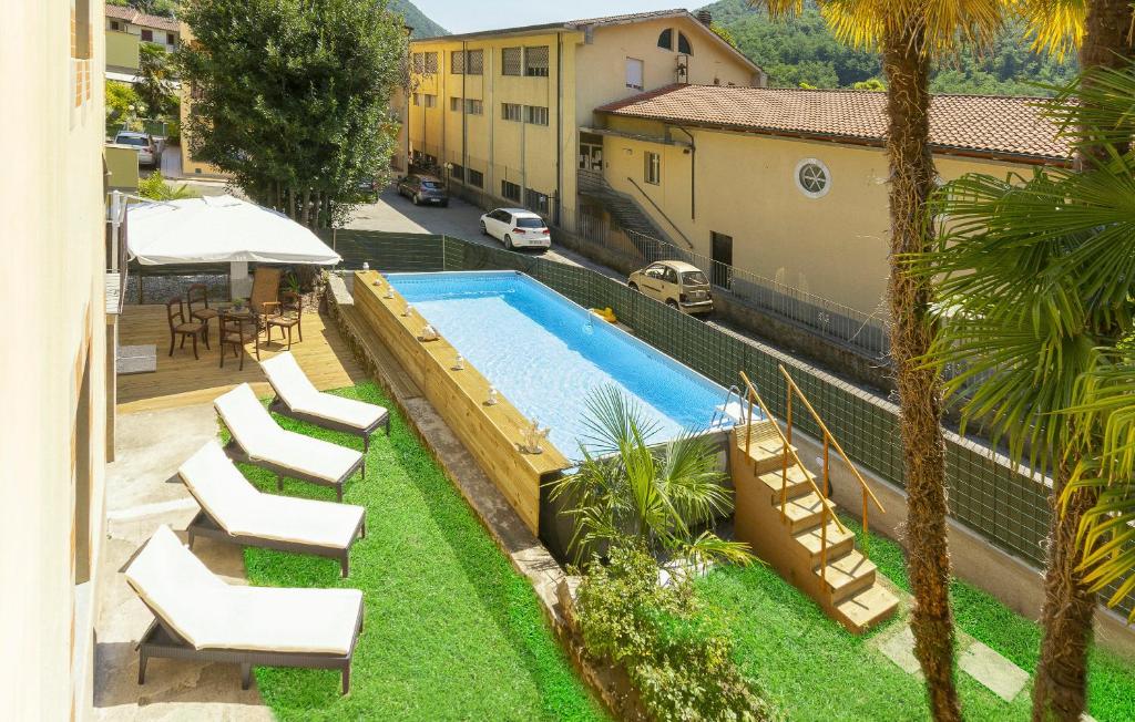 une piscine avec des chaises longues à côté d'un bâtiment dans l'établissement Villa Contessa, à Bagni di Lucca