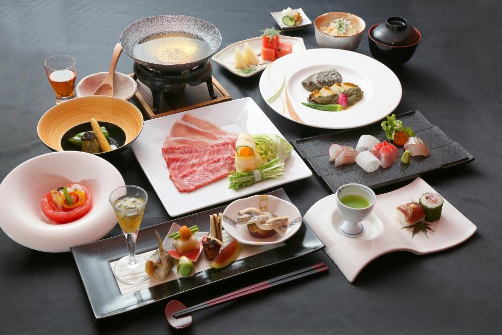 une table garnie d'assiettes de nourriture et de boissons dans l'établissement Hakone Yuyado Zen, à Hakone