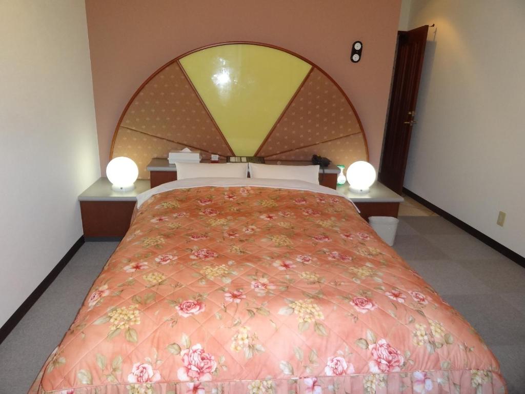 une chambre avec un grand lit avec une grande tête de lit dans l'établissement Hotel Sango (Adult only), à Muroran