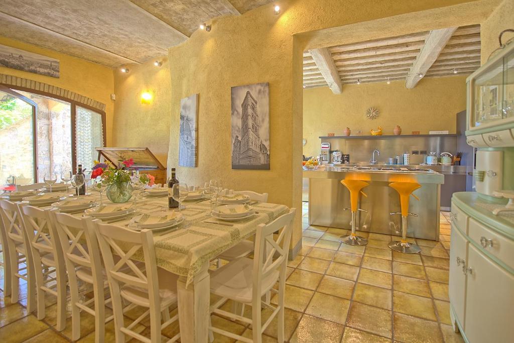 une salle à manger avec une table et une cuisine dans l'établissement Villa Sonia by PosarelliVillas, à San Donato in Poggio