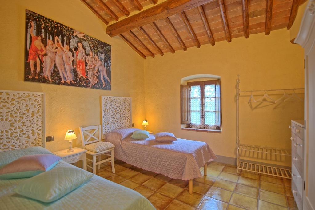 une chambre avec deux lits et un tableau au mur dans l'établissement Villa Sonia by PosarelliVillas, à San Donato in Poggio