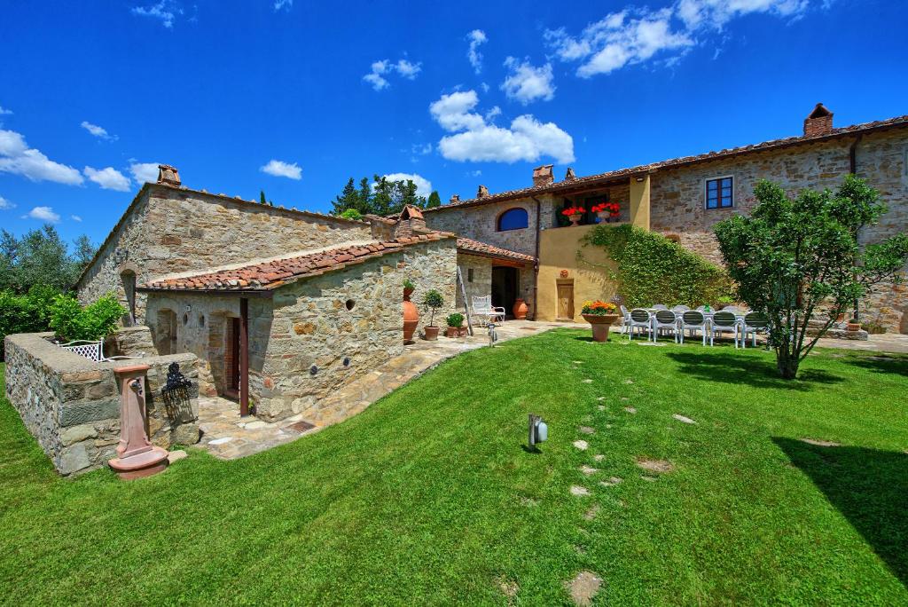une vue extérieure d'une maison en pierre avec une cour dans l'établissement Villa Sonia by PosarelliVillas, à San Donato in Poggio