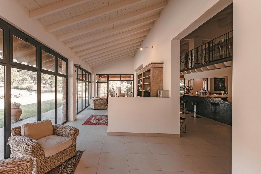 - une cuisine ouverte et un salon avec des chaises et un comptoir dans l'établissement Argentario Lagoon Resort & Spa, à Monte Argentario