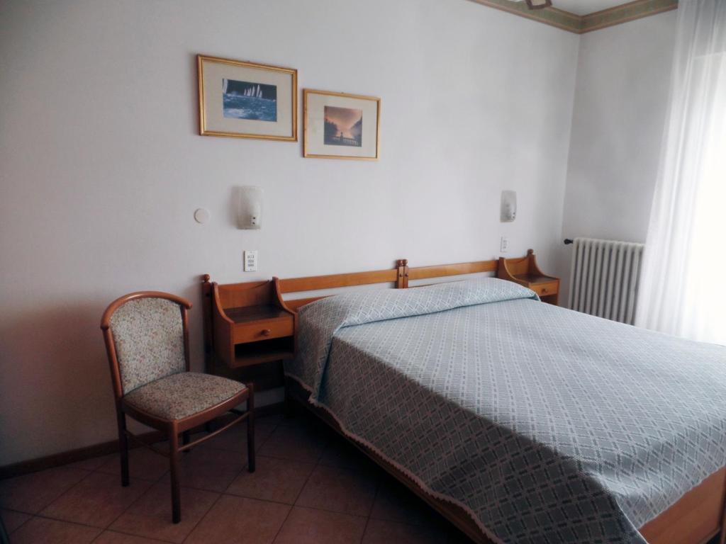 une chambre avec un lit, un bureau et une chaise dans l'établissement Piccolo Hotel Direkt am See, à Brenzone