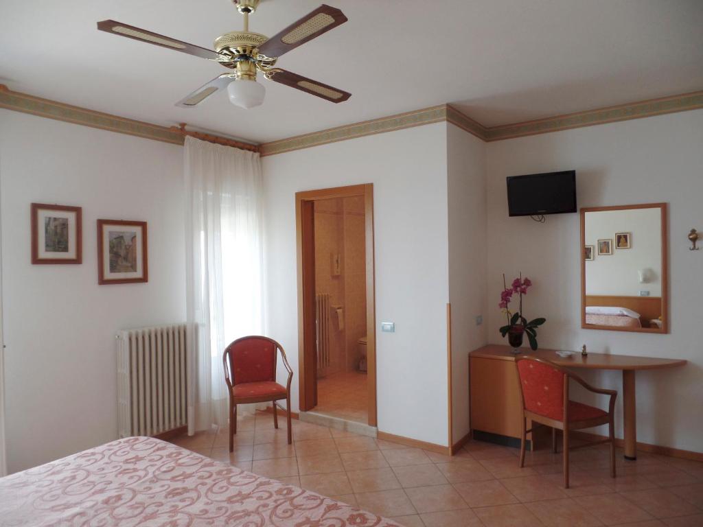 une chambre avec un lit, une table et des chaises dans l'établissement Piccolo Hotel Direkt am See, à Brenzone