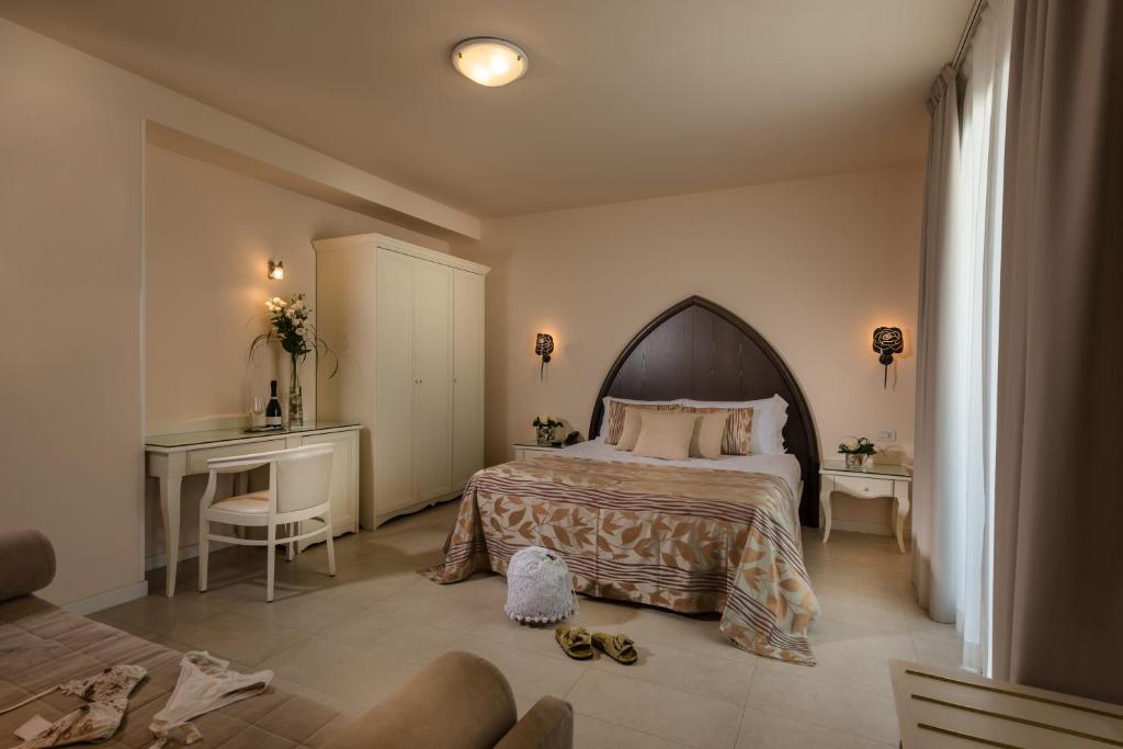 une chambre avec un lit et un bureau avec des chaussures sur le sol dans l'établissement Baia del Mar Beach Boutique Hotel, à Lido di Jesolo 61 autres photos