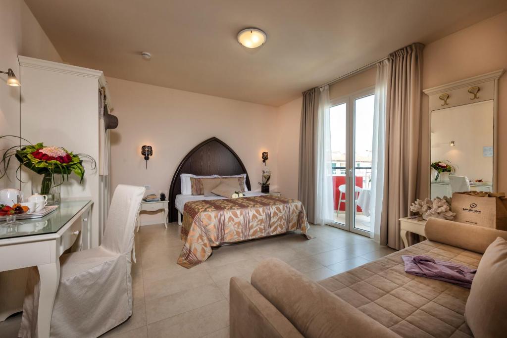 une chambre avec un lit et un salon dans l'établissement Baia del Mar Beach Boutique Hotel, à Lido di Jesolo