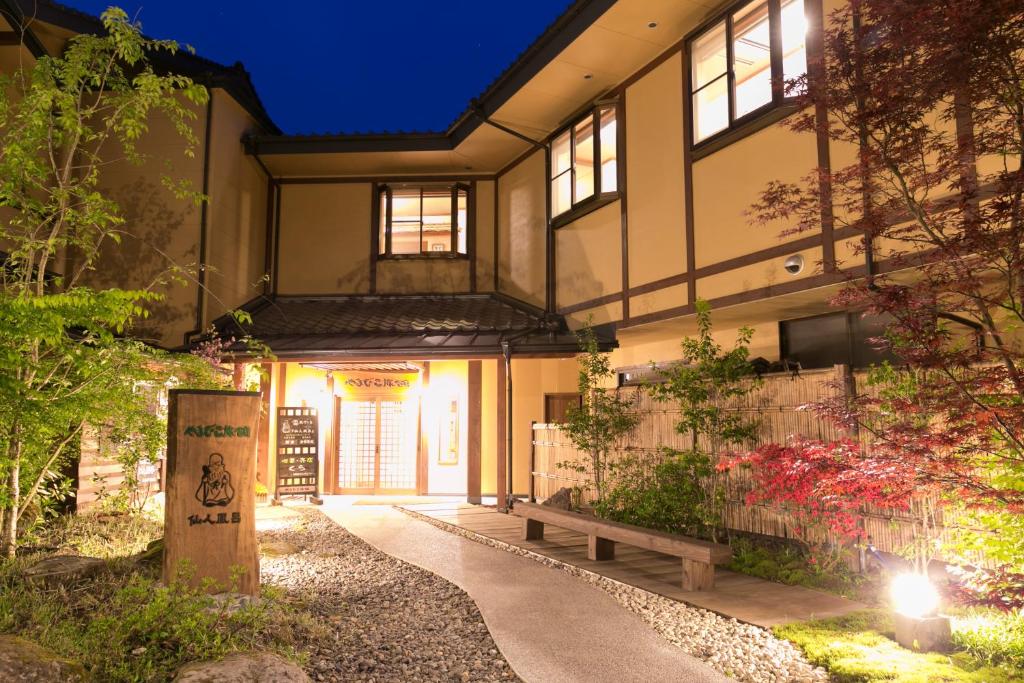 un bâtiment avec un banc devant lui dans l'établissement Yamabiko Ryokan, à Minamioguni