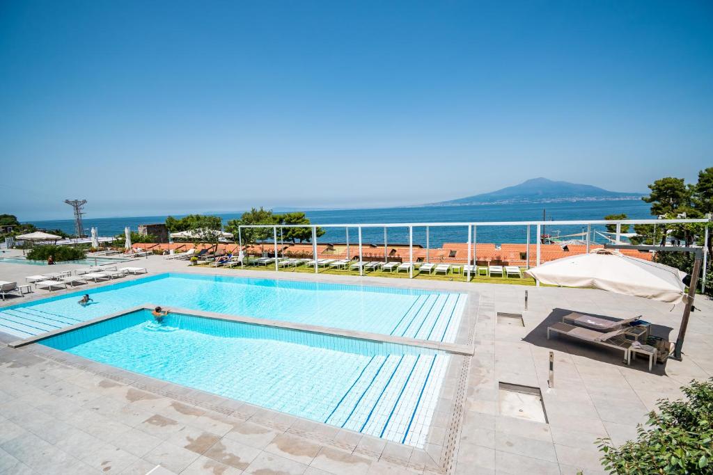 une grande piscine avec vue sur l'océan dans l'établissement Hotel Le Axidie, à Vico Equense