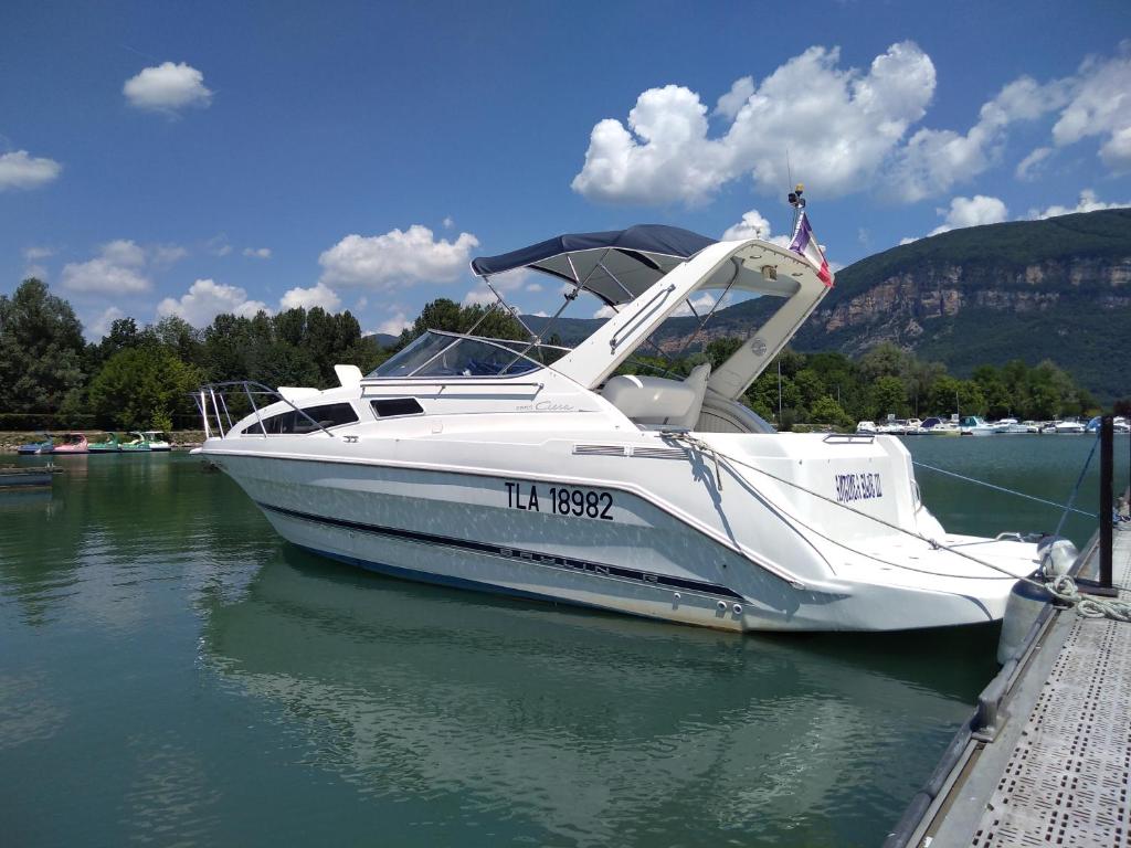 un bateau blanc amarré à un quai dans l'eau dans l'établissement Eden marine, à Montalieu-Vercieu