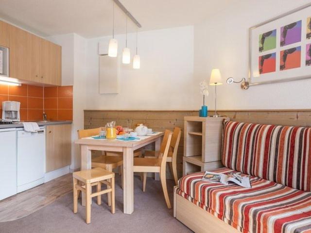 une cuisine et un salon avec une table et un canapé dans l'établissement Appartement La Tania 2 pièces garage dans chalet pied pistes, à La Tania