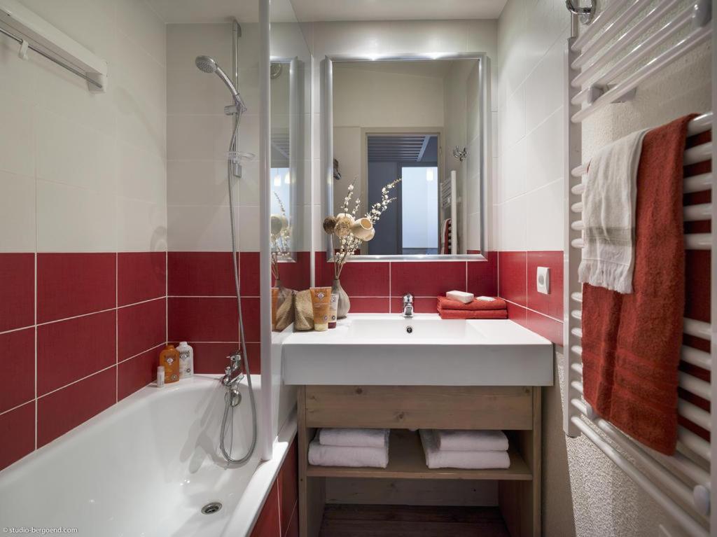 une salle de bain avec un lavabo, une baignoire et un miroir dans l'établissement Appartement La Tania 2 pièces garage dans chalet pied pistes, à La Tania