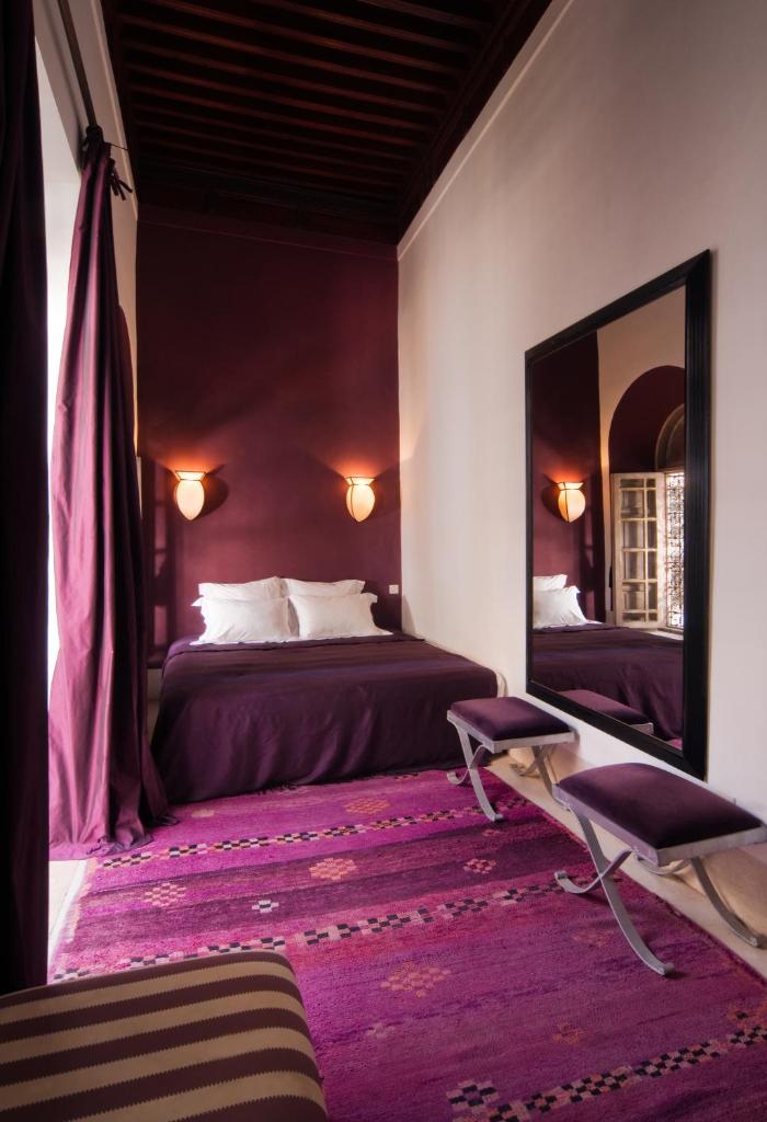 une chambre avec deux lits et un grand miroir dans l'établissement Riad Tzarra, à Marrakech