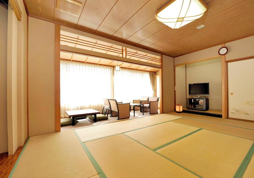 Cette grande chambre dispose d'un salon avec une grande fenêtre. dans l'établissement Itoen Hotel Shiobara, à Nasushiobara