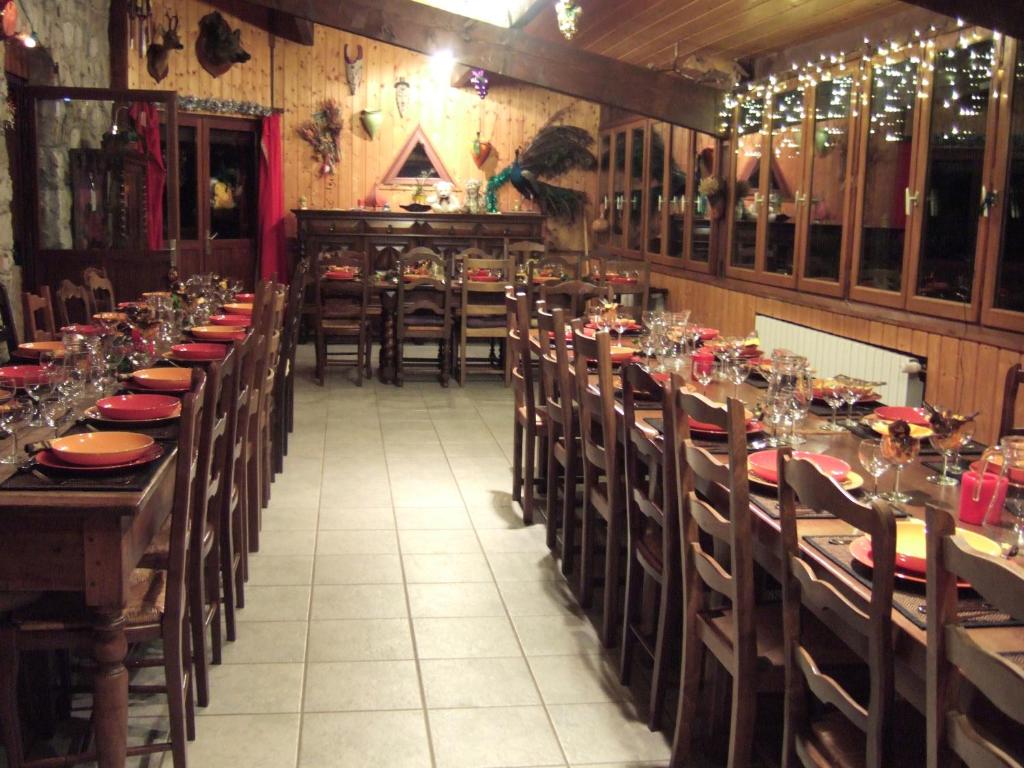 une salle à manger avec des tables et des chaises en bois et des assiettes rouges dans l'établissement Domaine du Rocher St-Loup, à Vif