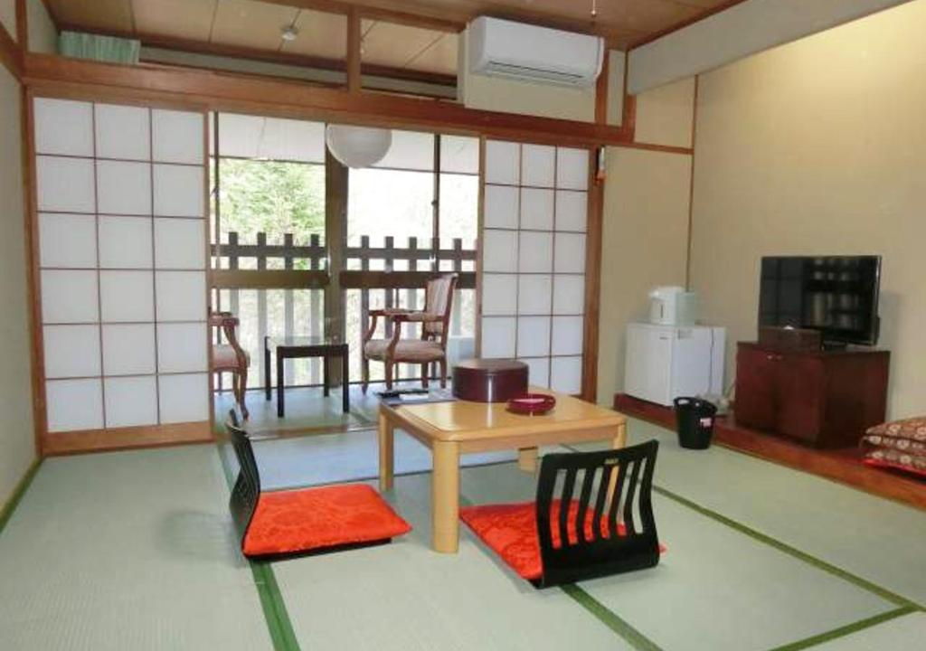 un salon avec une table et des chaises et une cuisine dans l'établissement Hotel Yunishigawa, à Nikkō 65 autres photos