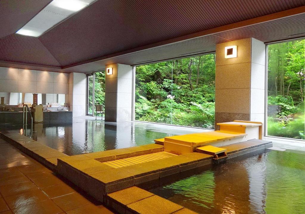 Chambre avec Piscine d'Eau et Bancs jaunes dans l'établissement Hotel Yunishigawa, à Nikkō