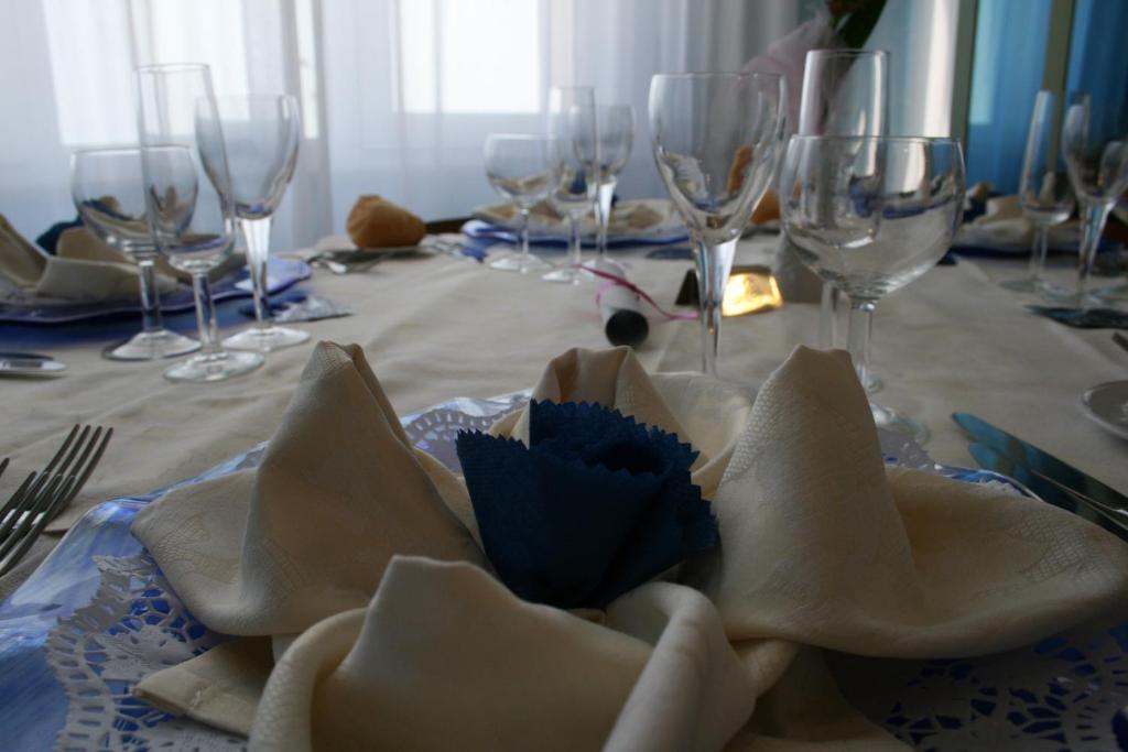 - une table avec des verres à vin et une assiette de nourriture dans l'établissement Hotel Giannino, à Porto Recanati
