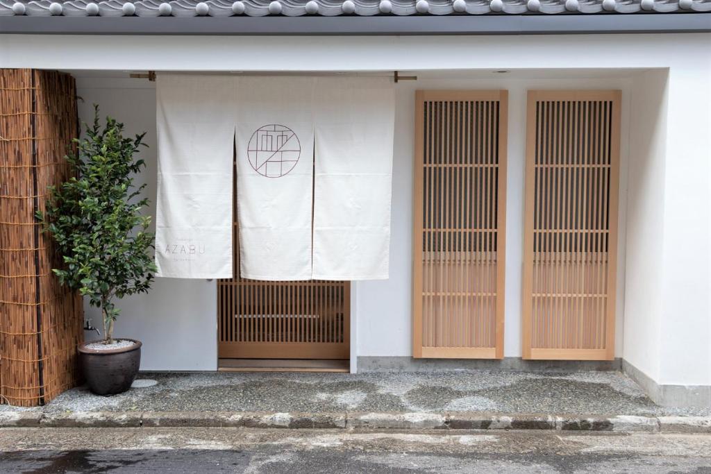 un bâtiment dont le côté comporte un drapeau dans l'établissement Auberge AZABU, à Kyoto