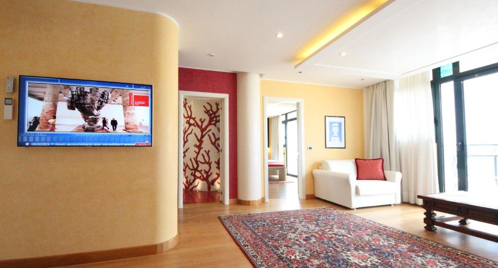 un salon avec une télévision à écran plat sur un mur dans l'établissement Ruhl Beach Hotel & Suites, à Lido di Jesolo