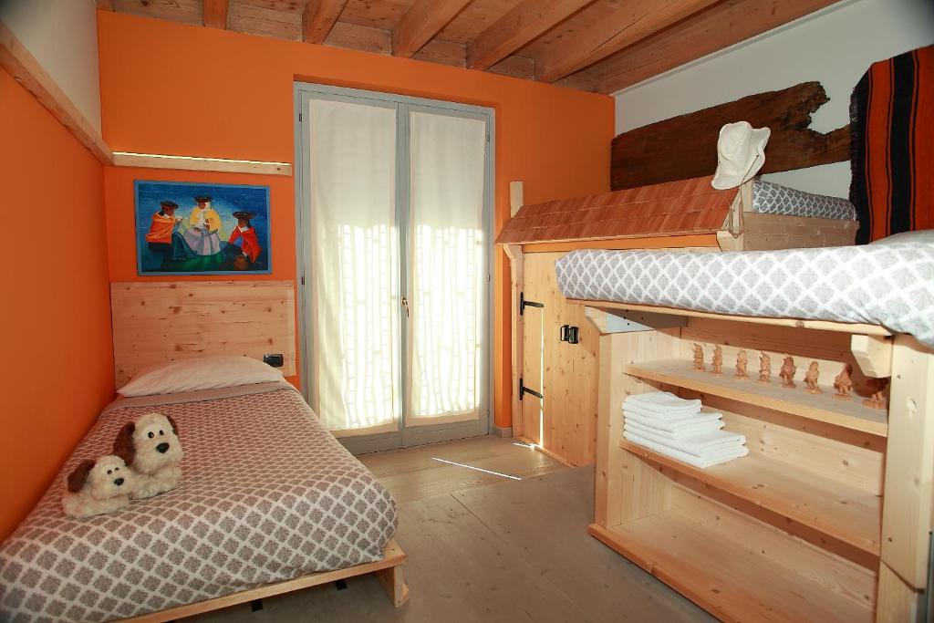 - une chambre avec des murs orange et des lits superposés dans l'établissement Villa Diamante, à Meina
