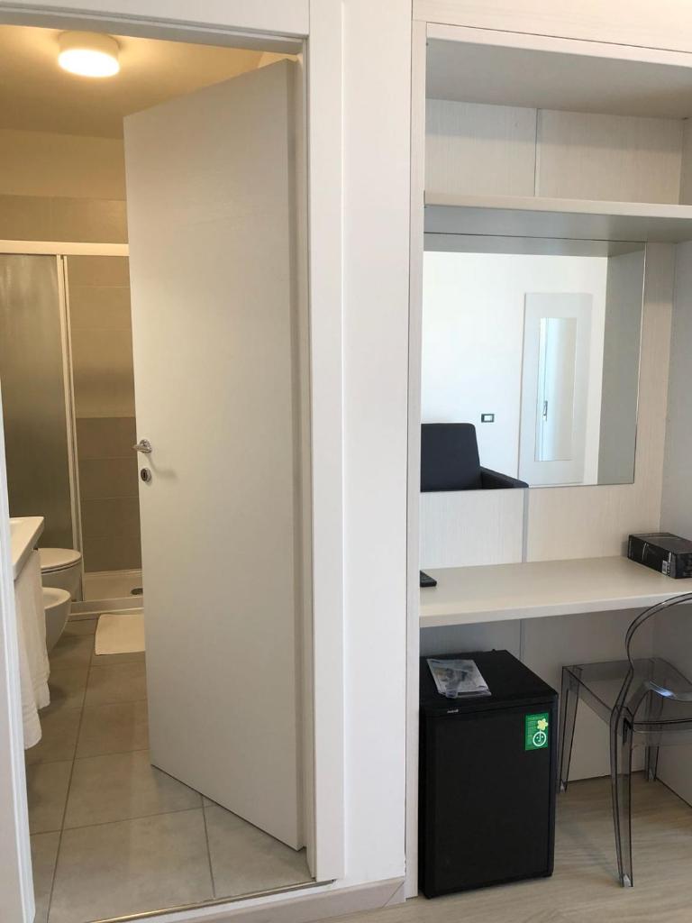 une porte ouverte menant à un bureau avec un bureau et une table dans l'établissement Hotel Portofino, à Caorle 96 autres photos