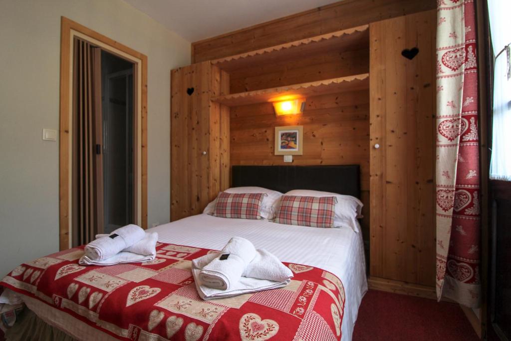 une chambre avec un lit avec des serviettes dessus dans l'établissement Hotel Le Christiania, aux Gets